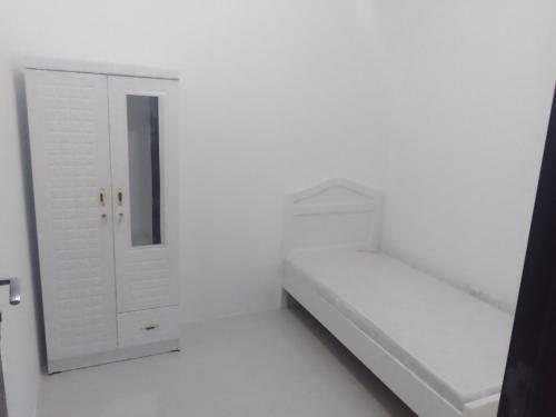 ein weißes Zimmer mit einer Schublade und einem Schrank in der Unterkunft SN Realestate Resedent in Abu Dhabi