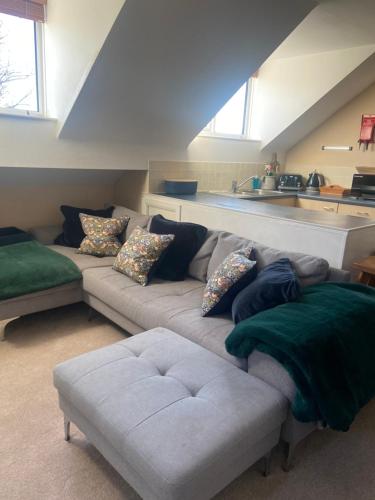 a living room with a couch and a kitchen at Little Hill View in Milton Ernest