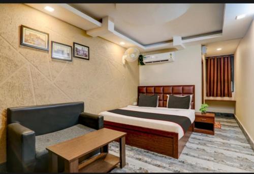 una camera d'albergo con letto e divano di Awadh court with large parking area a Lucknow