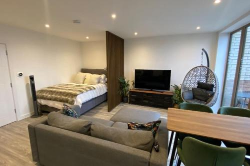 a bedroom with a bed and a couch and a television at London Luxe: Stylish Studio in London