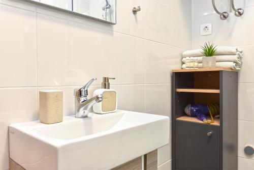 a bathroom with a white sink and a mirror at Apartment Loborika 1411 in Loborika