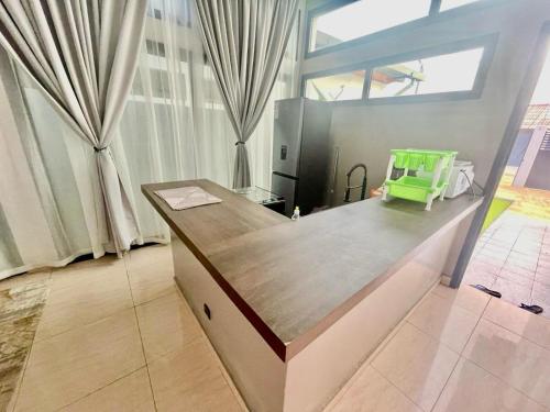 a kitchen with a counter with a green chair at Les merveilles d’assinie in Assinie