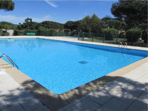 a large swimming pool with blue water at GASETIENNE Mazet T2 dans domaine avec piscines et tennis in Gassin