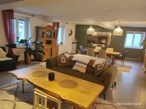 a living room with a couch and a table at Grande maison de campagne in Villiers-en-Désoeuvre