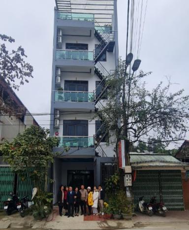 eine Gruppe von Personen, die vor einem Gebäude stehen in der Unterkunft Nhà nghỉ Hậu Hà in Tuyên Quang