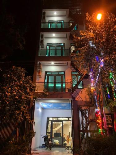 ein hohes Gebäude mit einer nachts beleuchteten Fassade in der Unterkunft Nhà nghỉ Hậu Hà in Tuyên Quang