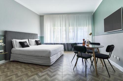 - une chambre avec un lit et une table avec des chaises dans l'établissement Brera Boutique Suites Milano, à Milan