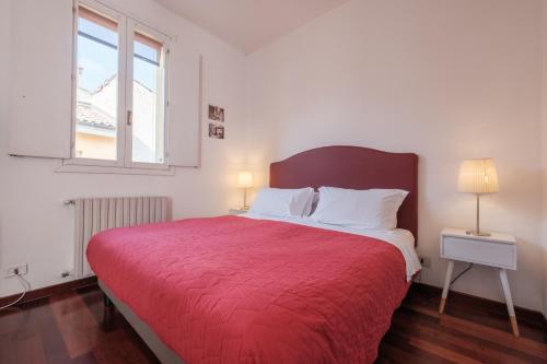 a bedroom with a red bed with a red blanket at Residence Studio Vita in Bologna