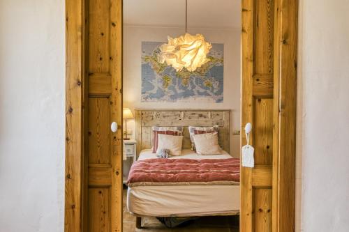 a bedroom with a bed and a chandelier at Casa vacacional Slow con piscina in Riumors