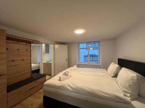 a bedroom with a large white bed and a window at The R Apartment Randen in Schaffhausen