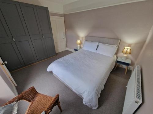 a bedroom with a large white bed and two lamps at Polruan - stunning central NQ house - dog friendly in New Quay