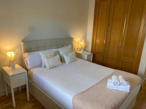 una camera da letto con un grande letto bianco con asciugamani di Playa Pacífico Apartment a Málaga