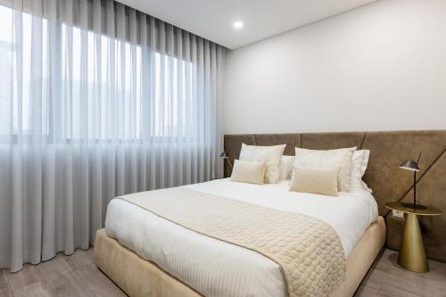um quarto com uma cama grande e uma janela grande em Boavista Executive Studios no Porto