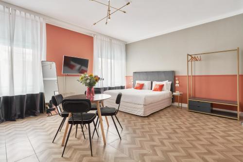 une chambre d'hôtel avec un lit, une table et des chaises dans l'établissement Brera Boutique Suites Milano, à Milan