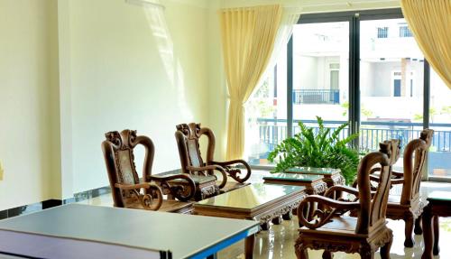 a dining room with a table and chairs and a window at Friendly Homestay in Kon Tum