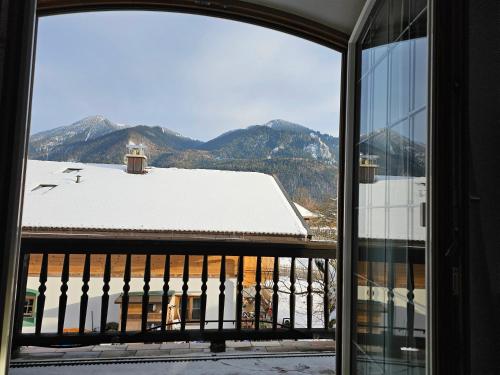 Aussicht aus einem Fenster eines Gebäudes mit einem schneebedeckten Dach in der Unterkunft Ferienwohnung Rebensburg in Point