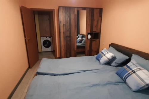 a bedroom with a large bed with blue and white pillows at Youthful Vibes near University, Free Parking in Ruse