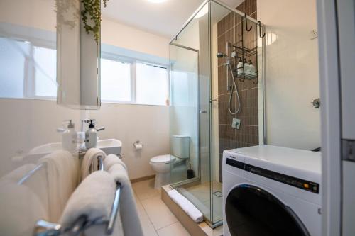 a bathroom with a shower and a toilet and a sink at Riverside apartment with city & Story Bridge view in Brisbane