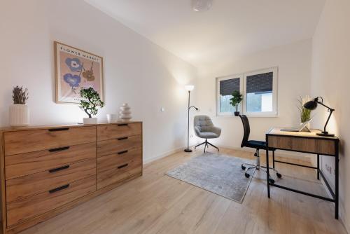 um escritório com uma cómoda, uma secretária e uma cadeira em Luxus-Neubauvilla am Tierpark em Alsdorf