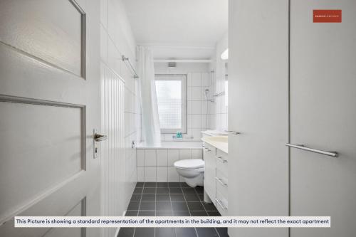 a white bathroom with a toilet and a sink at Apartment in the heart of Oerlikon in Zurich
