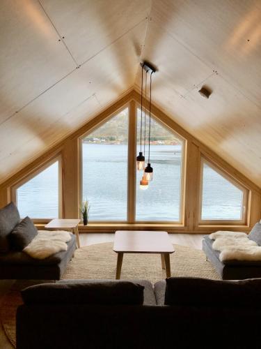 a living room with a large window with a view of the water at Fjordview Ryten 2 Retreat in Sund