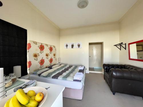 una sala de estar con una cama y un bol de fruta en 83 Eastlake drive en Ciudad del Cabo