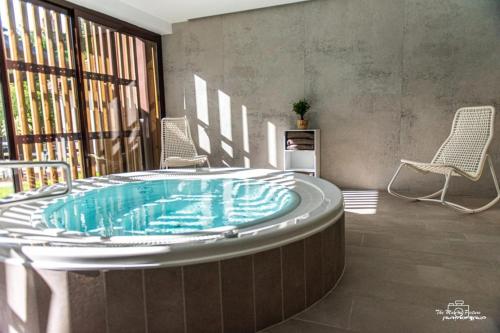 een jacuzzi in een kamer met 2 stoelen bij Logis Hôtel Altitude et Spa Pierre-Percée in Pierre-Percée