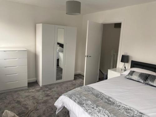 a bedroom with a bed and a dresser and a mirror at Manchester Home near Near City center and Stadium in Manchester