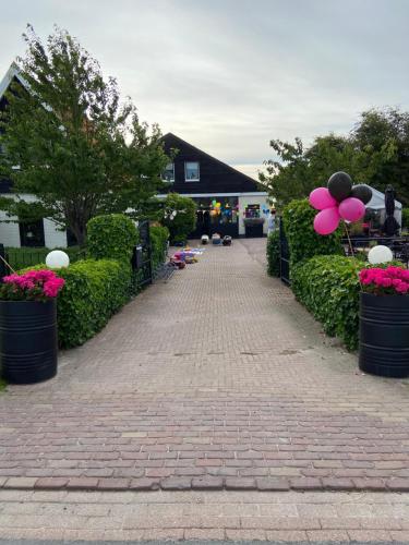 a brick walkway with pink and black balloons and flowers at By Mosk in Engelum