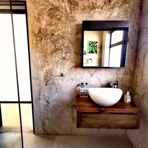 a bathroom with a sink and a mirror at Beachfront Townhouse - MowenOne in Walvis Bay