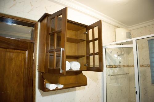 a bathroom with wooden cabinets and a shower at EXECUTIVE MASTER BEDROOM in Accra