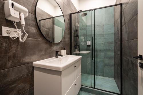 een badkamer met een witte wastafel en een douche bij R38 Boutique Apartments, Best Location by BQA in Boedapest