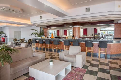a lobby with a bar with chairs and a table at Kosta Palace in Kos Town