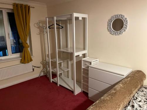 a bedroom with a white cabinet and a mirror at Room 2 - Chassagne Guest House in Church Coppenhall