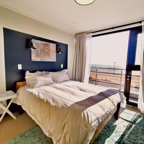 ein Schlafzimmer mit einem großen Bett und einem großen Fenster in der Unterkunft Beachfront Townhouse - MowenOne in Walvis Bay