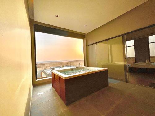 a bathroom with a large tub and a large window at شاليهات سي سايد in Khalij Salman