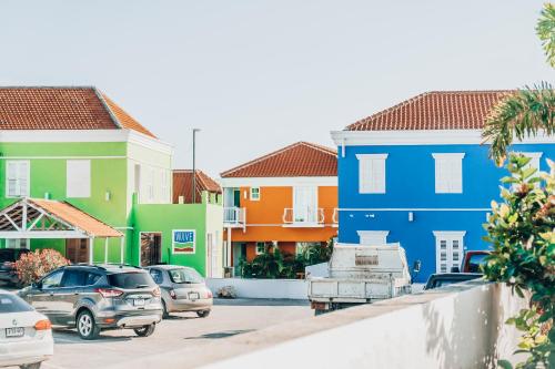 una fila di case con auto parcheggiate in un parcheggio di The Freedom Hotel a Willemstad
