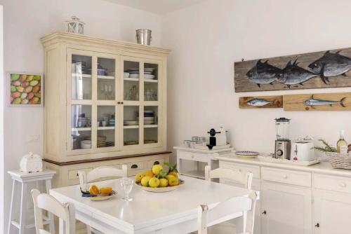 a kitchen with a white table with fruit on it at Villa Le Pigne in Favignana