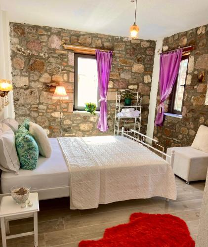 - une chambre avec un lit et un mur en pierre dans l'établissement Masal Küçükköy Boutiquehotel, à Ayvalık