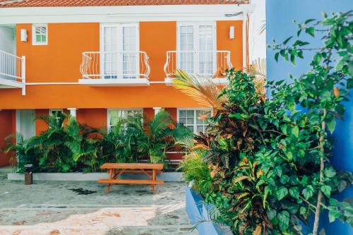 un edificio arancione con un tavolo da picnic di fronte di The Freedom Hotel a Willemstad