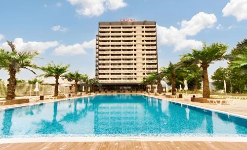 ein großer Pool mit einem Hotel im Hintergrund in der Unterkunft Europe Hotel & Casino All Inclusive in Sonnenstrand