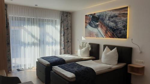 a hotel room with two beds and a window at Ferienapartments Pension Elsternest in Bad Liebenwerda
