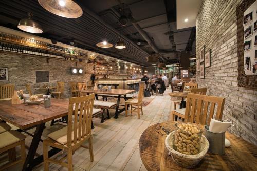 a restaurant with wooden tables and chairs and a brick wall at LOFT Hotel Bratislava in Bratislava