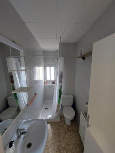 bagno bianco con lavandino e servizi igienici di Casa di Maritz 10a a Palafolls