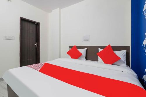a bedroom with a bed with red and white pillows at OYO Flagship R.S. RESIDENCY in New Delhi