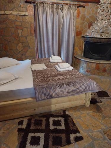 a bed in a room with a stone fireplace at Vip Kalavrita in Kalavrita