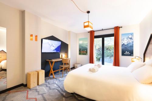 a hotel room with a bed and a desk at Hotel Base Camp Lodge - Albertville in Albertville