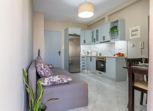 a living room with a couch and a kitchen at Liros House in Nafpaktos