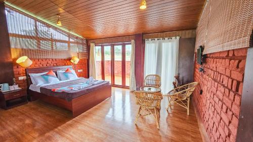 a bedroom with a bed and a table and chairs at Nature full Resort in Masinagudi