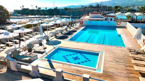 a swimming pool with lounge chairs and a resort at Kosta Palace in Kos Town